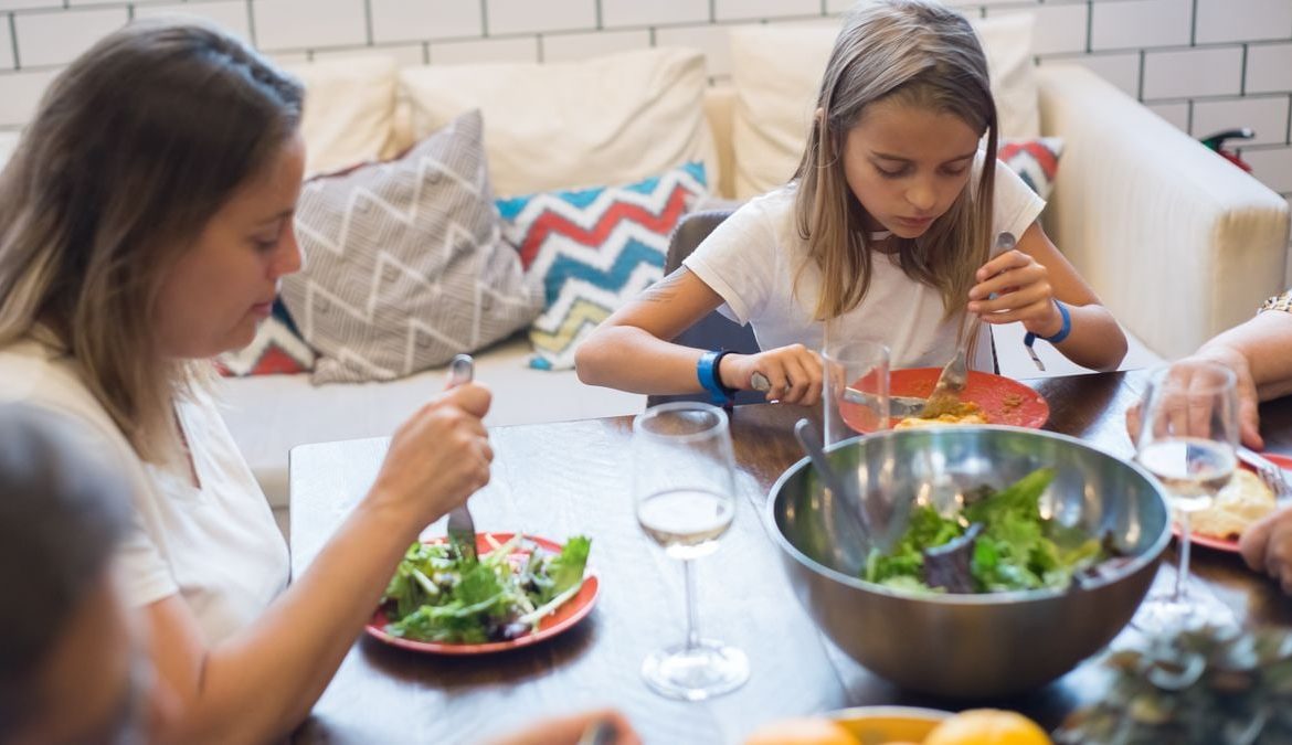 A family enjoying a healthy meal together indoors, emphasizing togetherness and healthy eating.